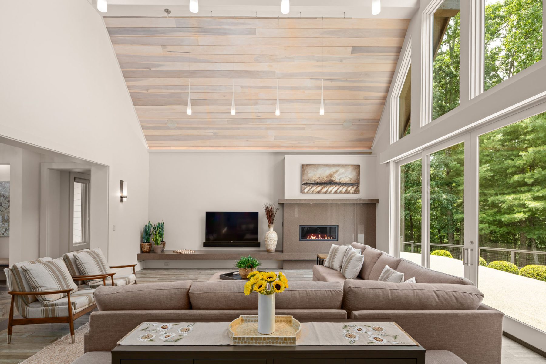 Luxury Home Builders Asheville NC. Set amidst an idyllic private setting, this home features a four-season room with stone fireplace by Osada Construction