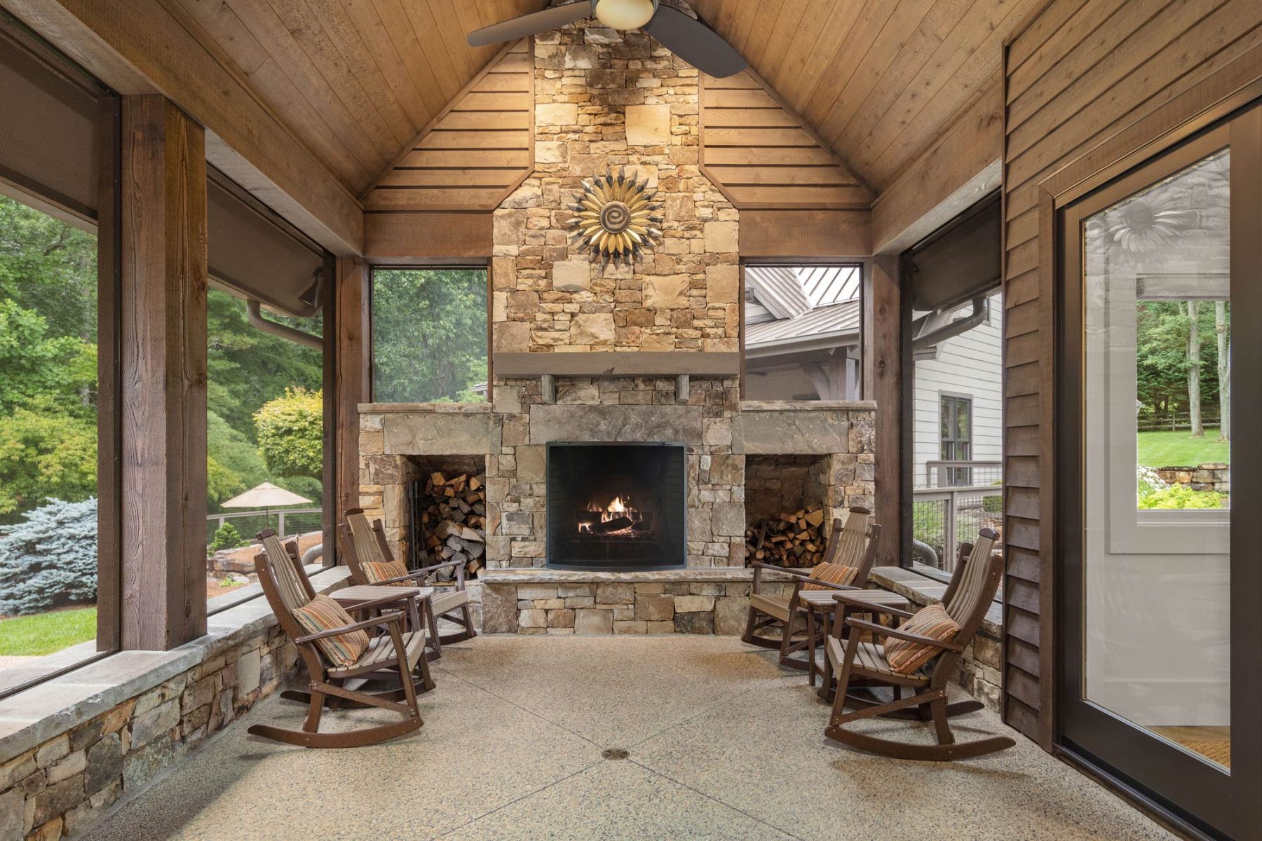 Luxury Home Builders Asheville NC. Set amidst an idyllic private setting, this home features a four-season room with stone fireplace by Osada Construction